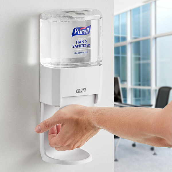 Purell wall-mounted hand sanitizer dispenser in use